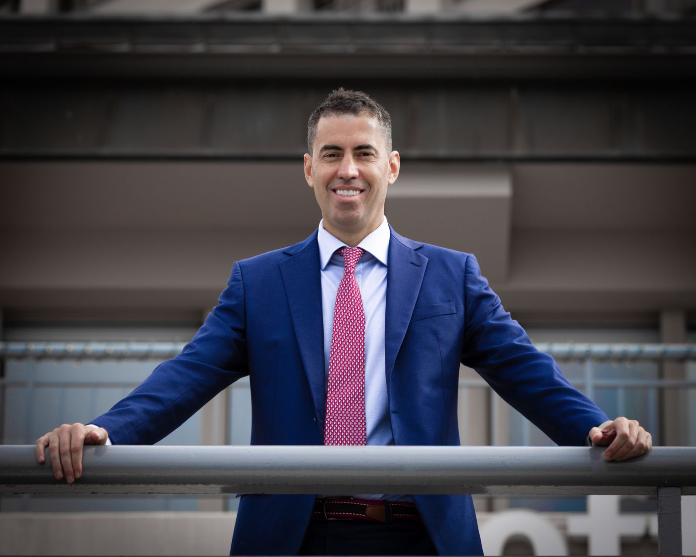 Profissional confiante de terno azul, sorrindo, depois de decidir seguir a carreira de Educador Financeiro