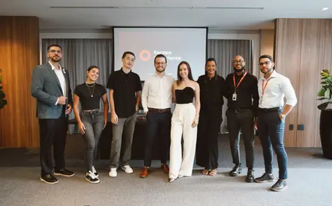 Alunos e o time do Grupo Karppa juntos no Karppa Experience, na frente do telão do evento
